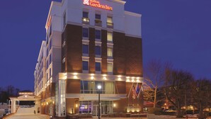 A Hilton Garden Inn with a brick facade, large windows, and a well-lit entrance. - Hilton Garden Inn Falls Church (Falls Church)