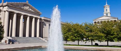 A classical building with a fountain in front.