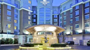 A hotel entrance with a central sculpture, multiple floors, and a clear sky. - Homewood Suites by Hilton Nashville Vanderbilt, TN (Nashville)