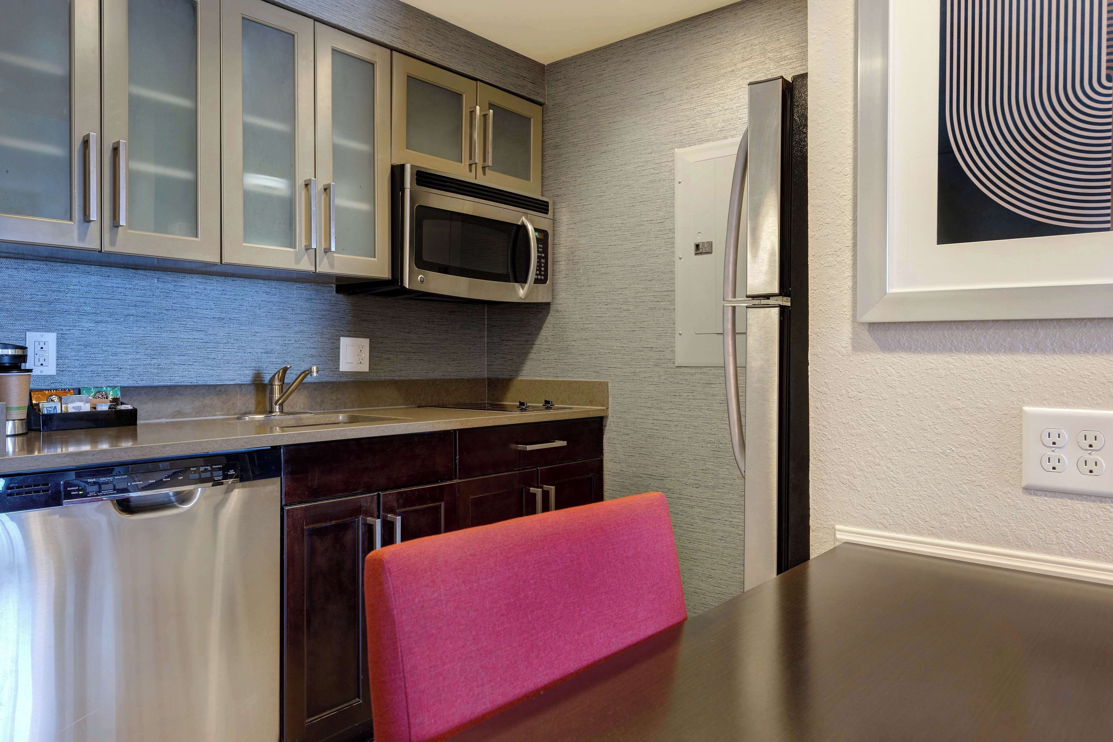 A kitchen with stainless steel appliances, a dishwasher, and a refrigerator.
