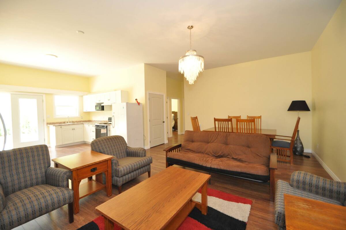 A living room with a sofa, chairs, a wooden coffee table, and a chandelier.
