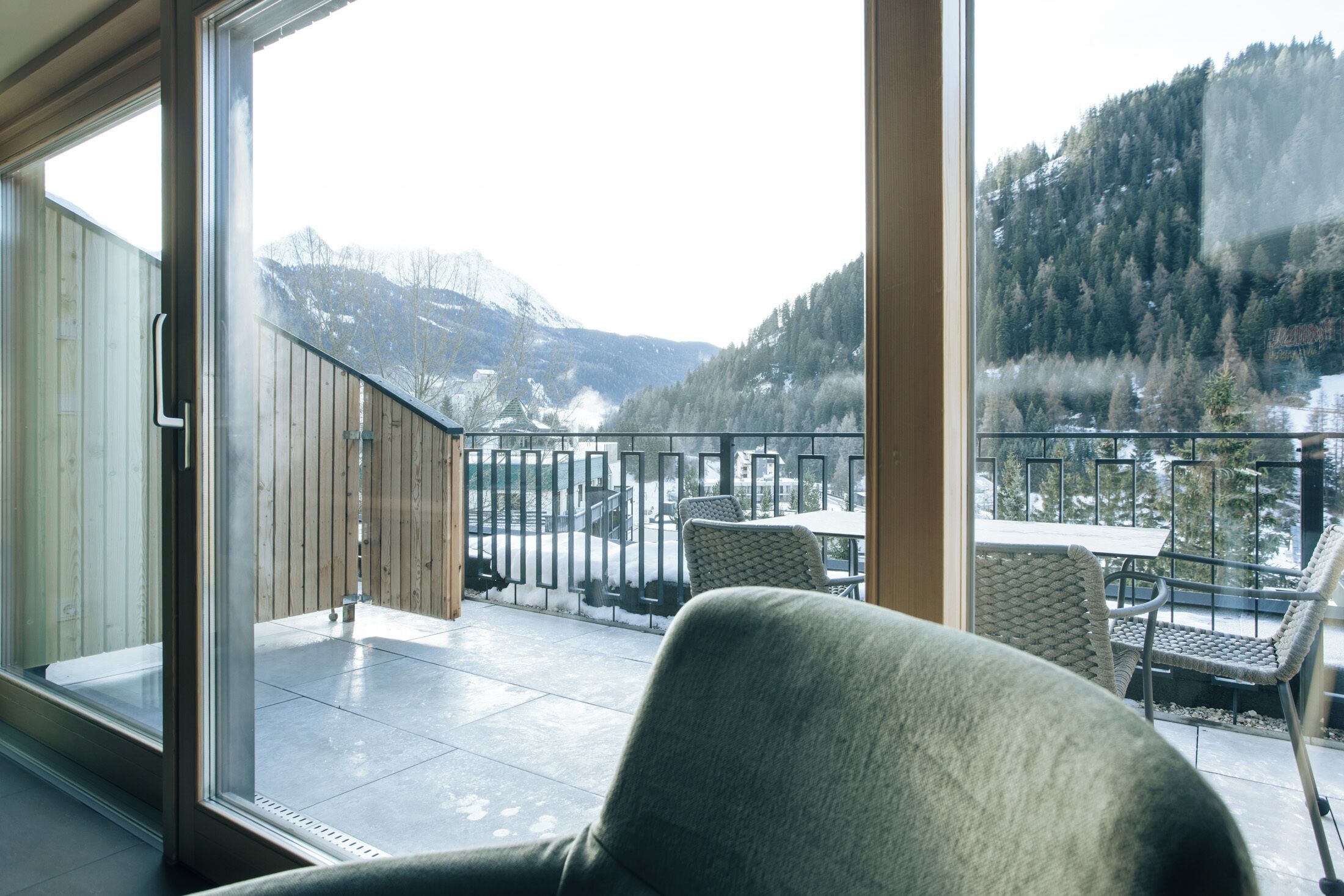 Ein Balkon mit Blick auf verschneite Berge und einen See.