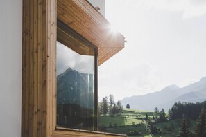 A room with a large window offering a view of a mountainous landscape. - Arabella Retreat & Spa (Nauders)