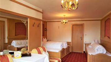 A hotel room with two beds, a chandelier, a mirror, and a small table with a wellness card.