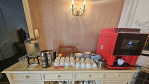 Un buffet avec une machine à café, de la verrerie et des assiettes.