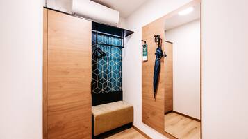 A walk-in closet with a bench, a geometric-patterned wall, and a mirror.