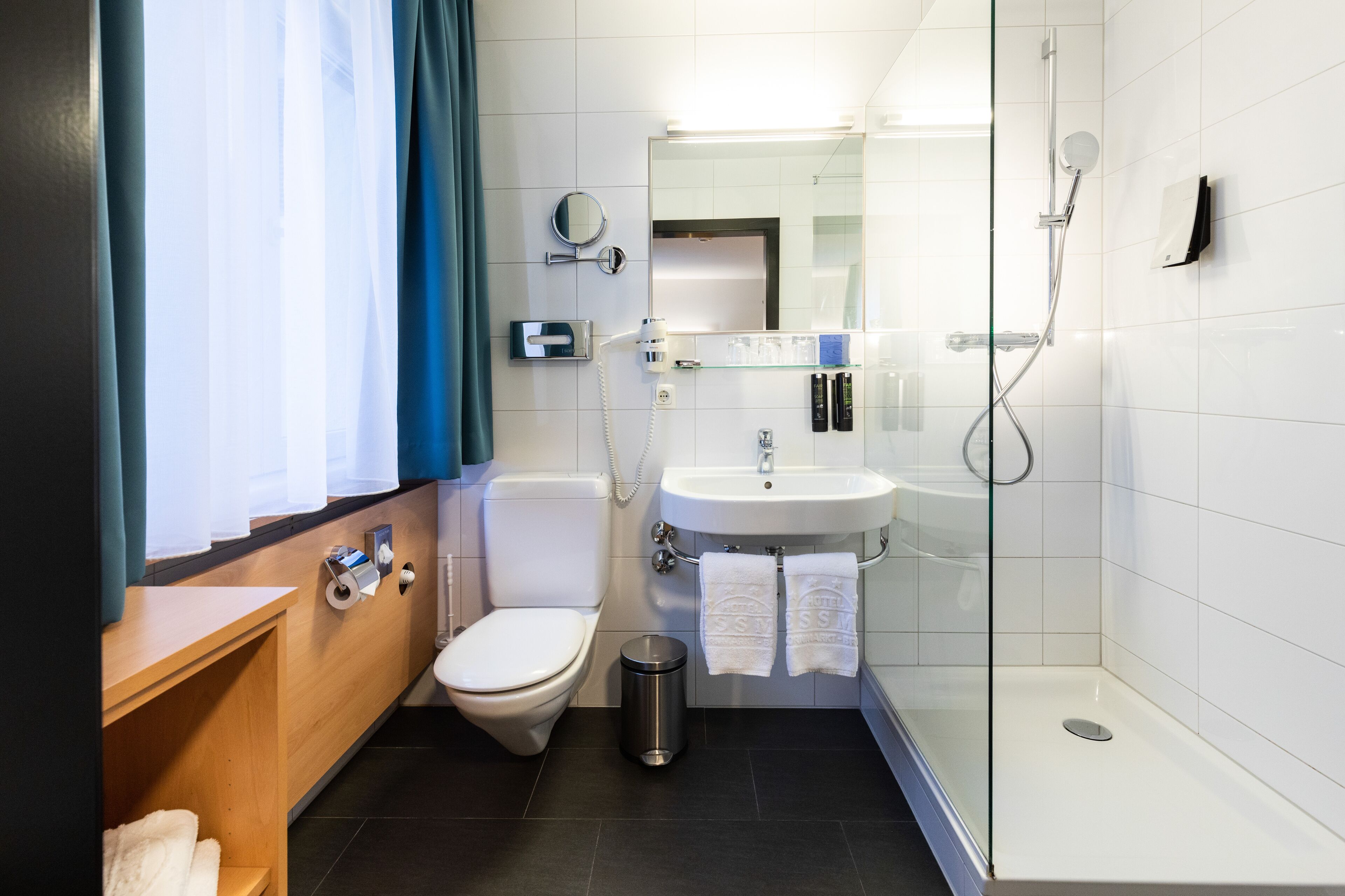 A modern bathroom with a toilet, sink, and shower.