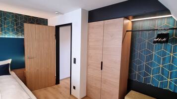 A bedroom with a bed, wardrobe, and bench.