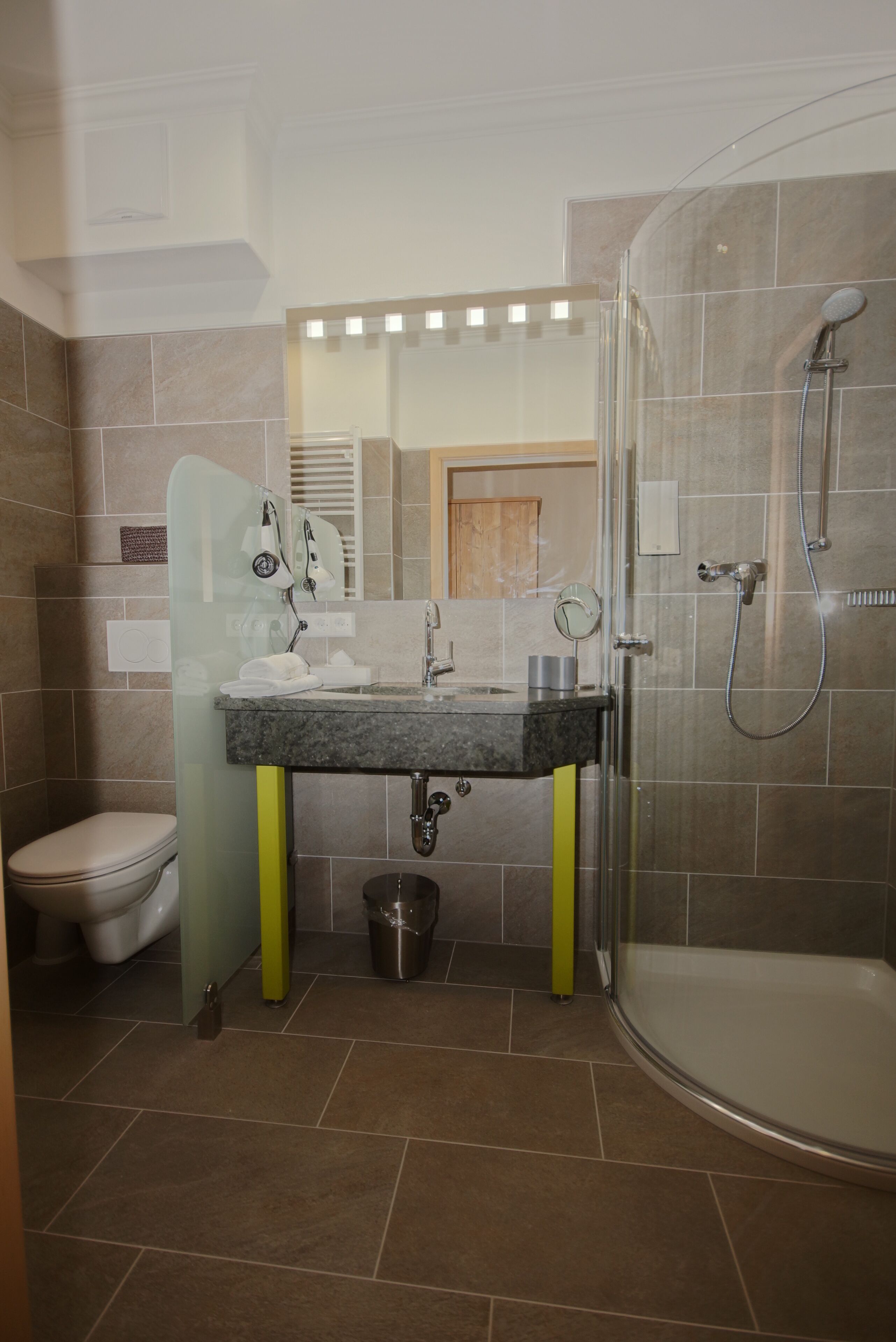 Ein Badezimmer mit Toilette, Waschbecken, Spiegel und Dusche.