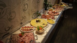 A buffet table with various food items and a decorative wall in the background. - Hotel Kufsteinerhof (Kufstein)