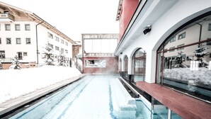Area piscina con vista libera sugli edifici circostanti e un pontile in legno.