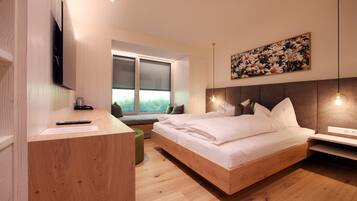 Un dormitorio moderno con una cama de madera, un escritorio y una ventana con vistas a zonas verdes.