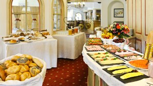 Buffet com diversos alimentos e um arranjo decorativo.