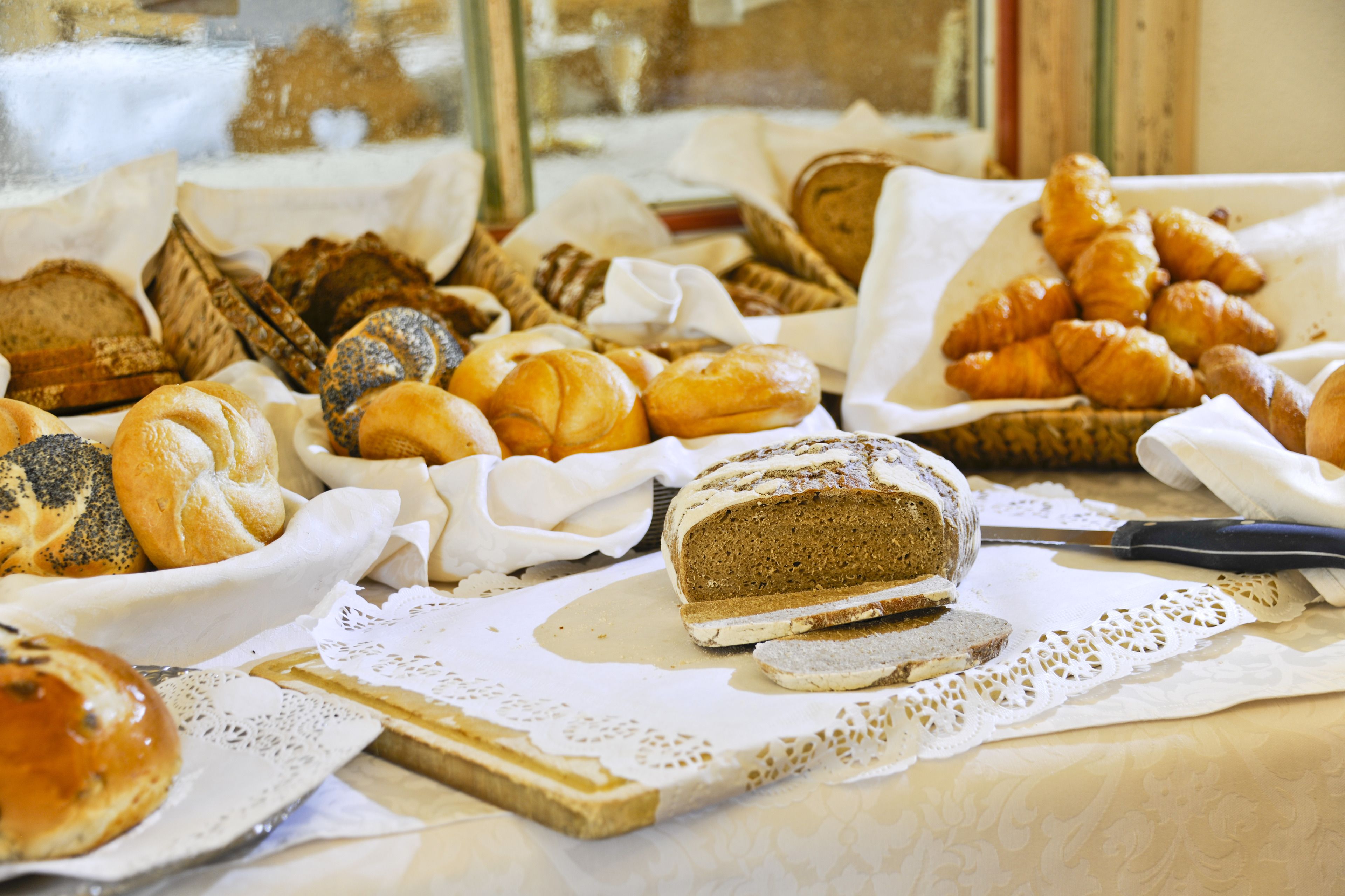 A variety of baked goods displayed on a table with a lace doily.
