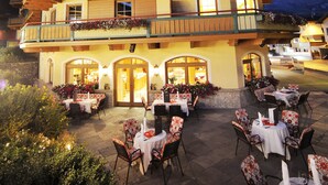 A hotel with multiple balconies, outdoor seating, and a mountain backdrop. - Sporthotel Kirchler (Tux)