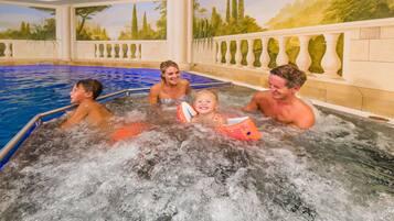 A hot tub area with a mural of a tropical landscape on the walls.