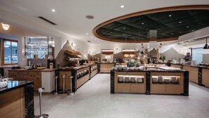 A spacious kitchen with multiple islands, wooden cabinets, and a variety of kitchenware. - Hotel Salzburger Hof (Altenmarkt im Pongau)