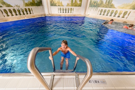 Una piscina techada, sillones reclinables de piscina