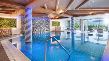 Una piscina techada, sillones reclinables de piscina