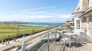 Ett hotell vid kusten med en balkong som vetter ut mot en golfbana och havet.
