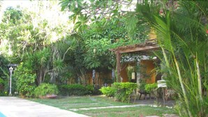 A garden with a pool, a pergola, and various plants. - Hotel La Brise (Cabo Frio)