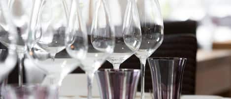 A table set with wine glasses and a white tablecloth.