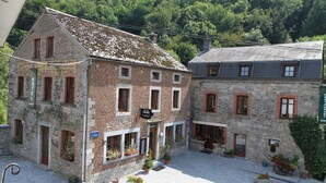 A historic building with a brick facade, multiple windows, and a sign indicating it is a hotel. - Hotel a la Ferme (Ferrieres)