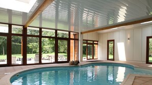 An indoor swimming pool with clear views of the outdoors, large windows, and a tiled floor. - Hotel a la Ferme (Ferrieres)