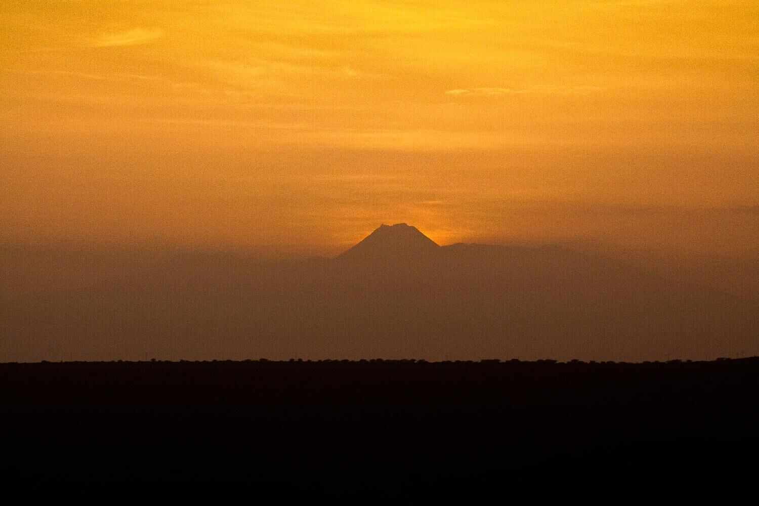 Silueta de montaña contra un cielo al atardecer.