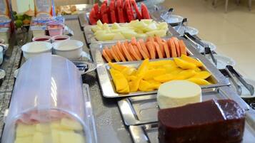 Un buffet con diversi alimenti, tra cui frutta, verdura e latticini.