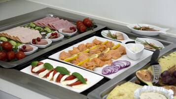 Un bufé con diversos alimentos, incluyendo carnes, quesos y adornos.