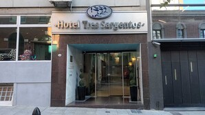 The entrance to Hotel Tres Sargentos with a modern facade, glass doors, and potted plants. - Hotel Tres Sargentos (Buenos Aires)