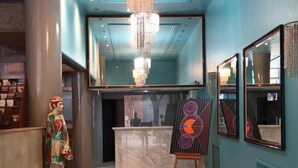 A hotel lobby with a chandelier, a reception desk, and artwork on the walls. - Hotel Tres Sargentos (Buenos Aires)