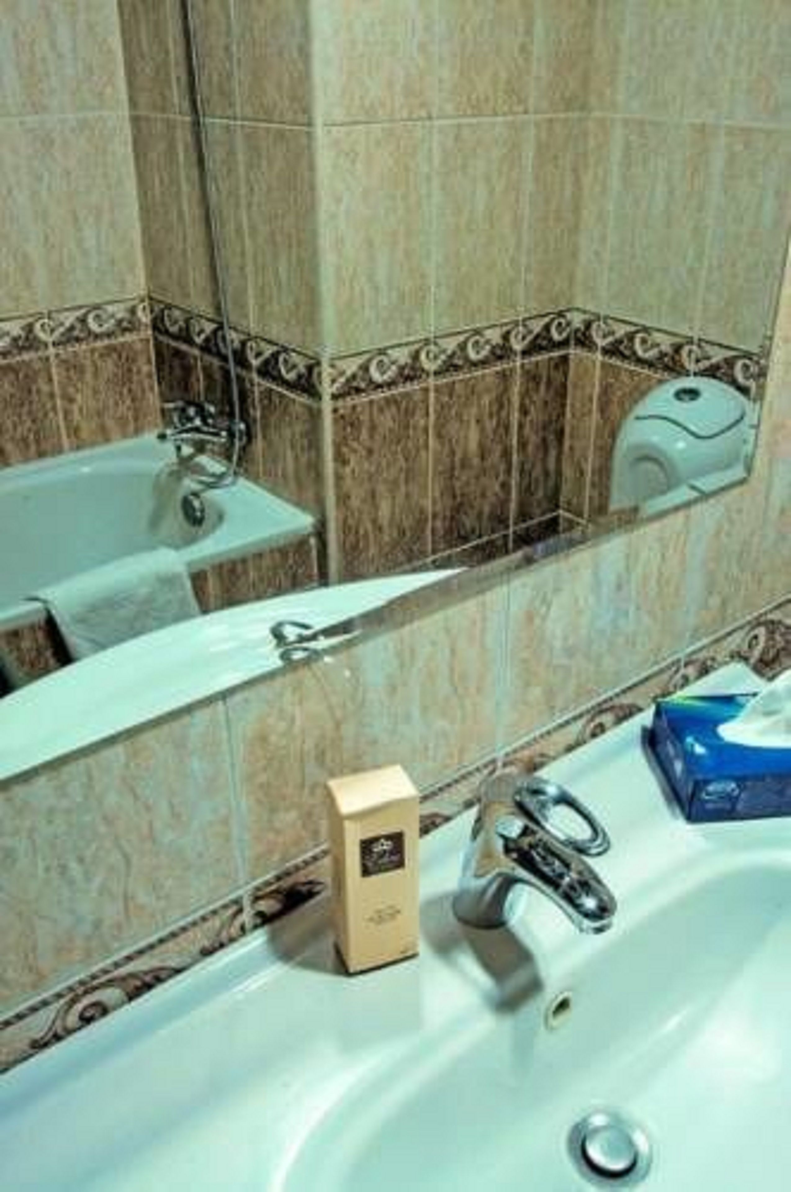 A bathroom with a sink, mirror, and a towel rack.