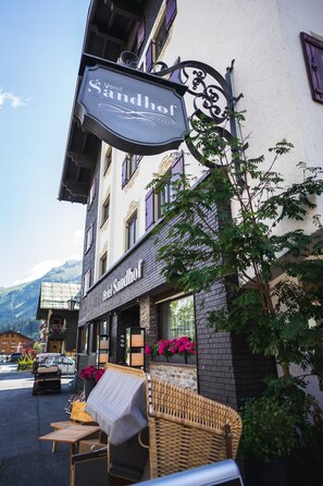 Hotel Sandhof, con terraza exterior y vistas a la montaña.