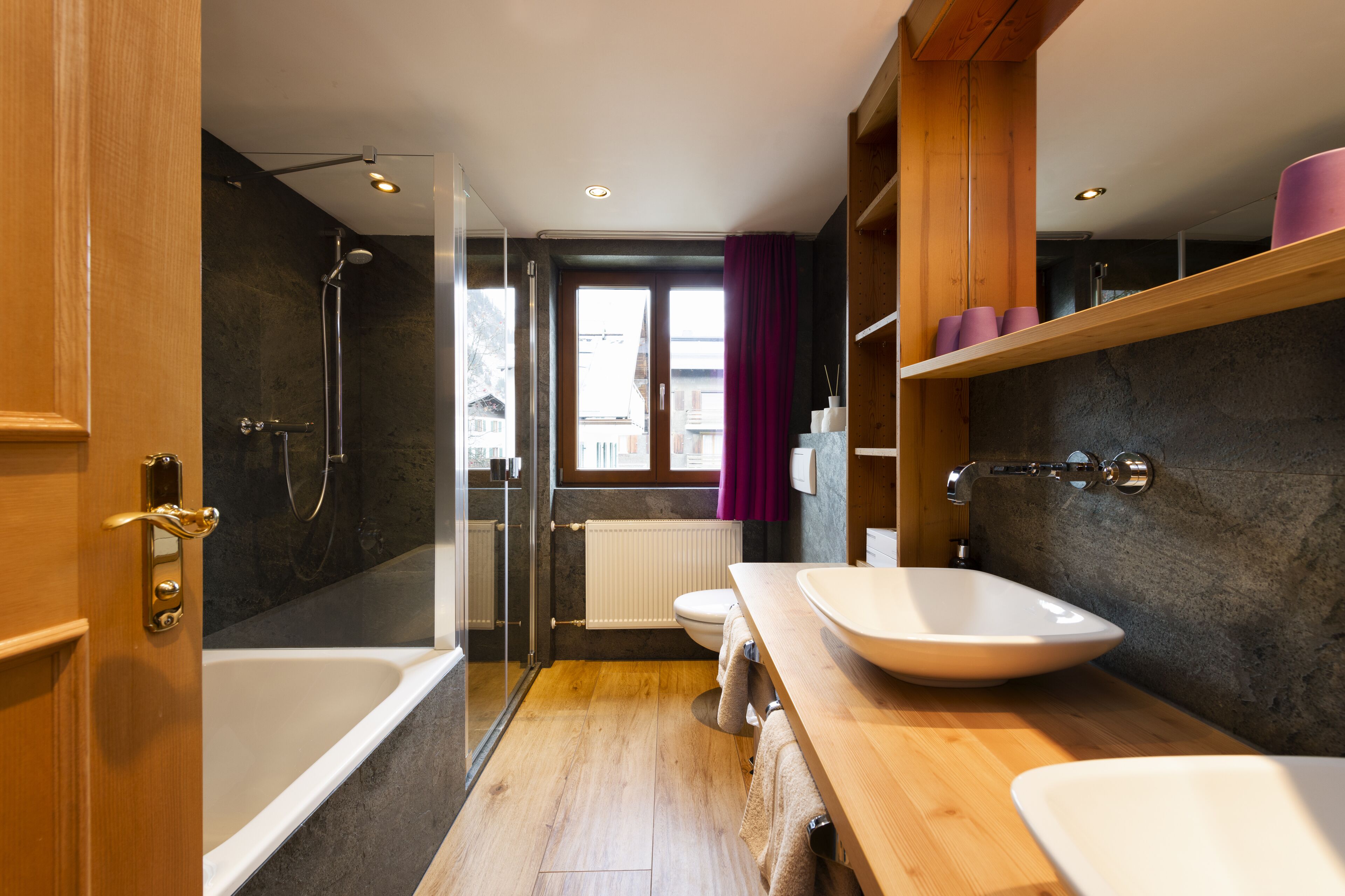 A modern bathroom with a bathtub, shower, and a large sink.