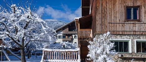 A wooden building with a balcony and a snow-covered landscape.