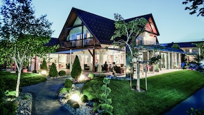 A modern two-story house with a large balcony, a covered patio, and a well-maintained garden. - Hotel Garni Birkenhof (Bad Radkersburg)