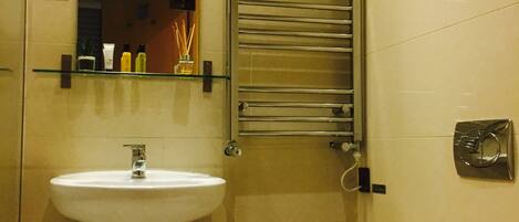 A bathroom with a white sink, a toilet, and a towel rack.