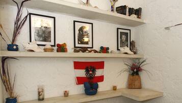 A bathroom with a toilet, shelves with various items, and a flag.
