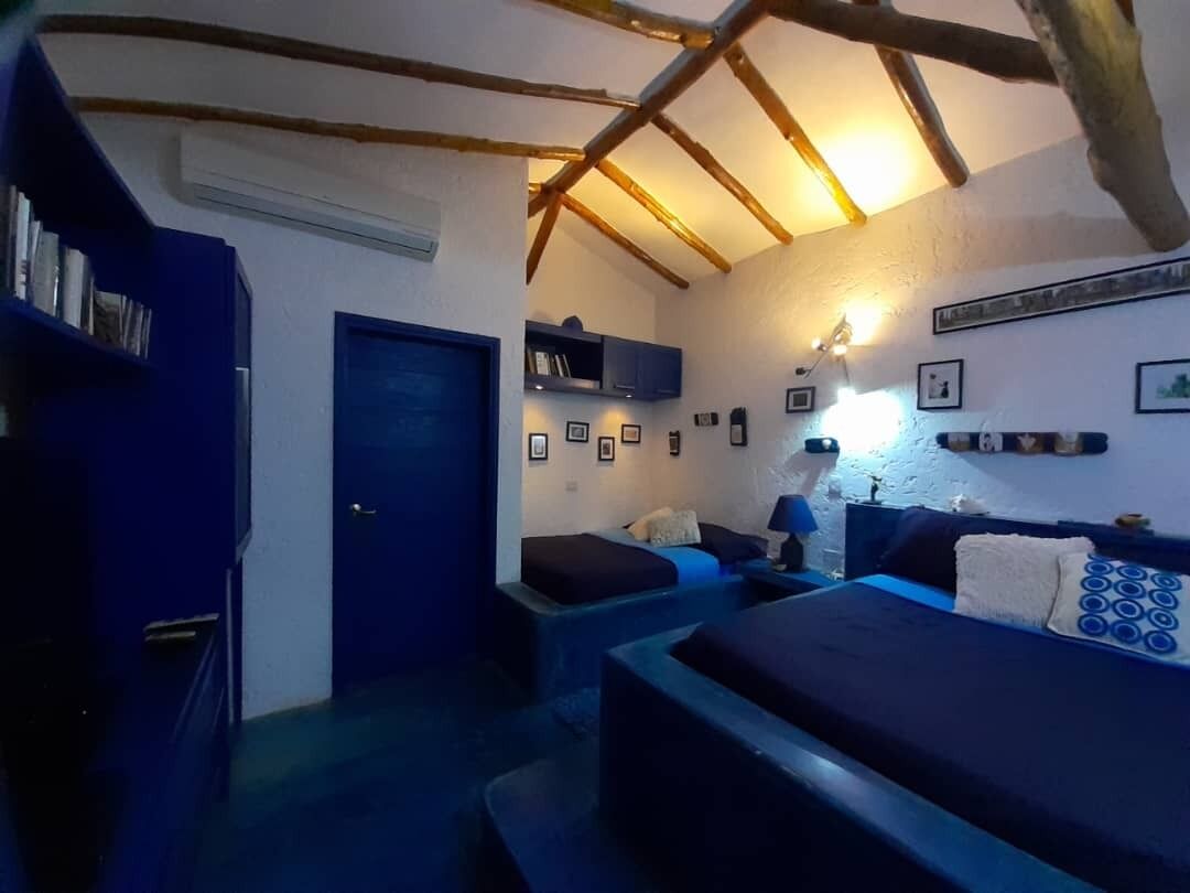 Un dormitorio acogedor con techo inclinado, una cama, una mesita de noche y un armario.