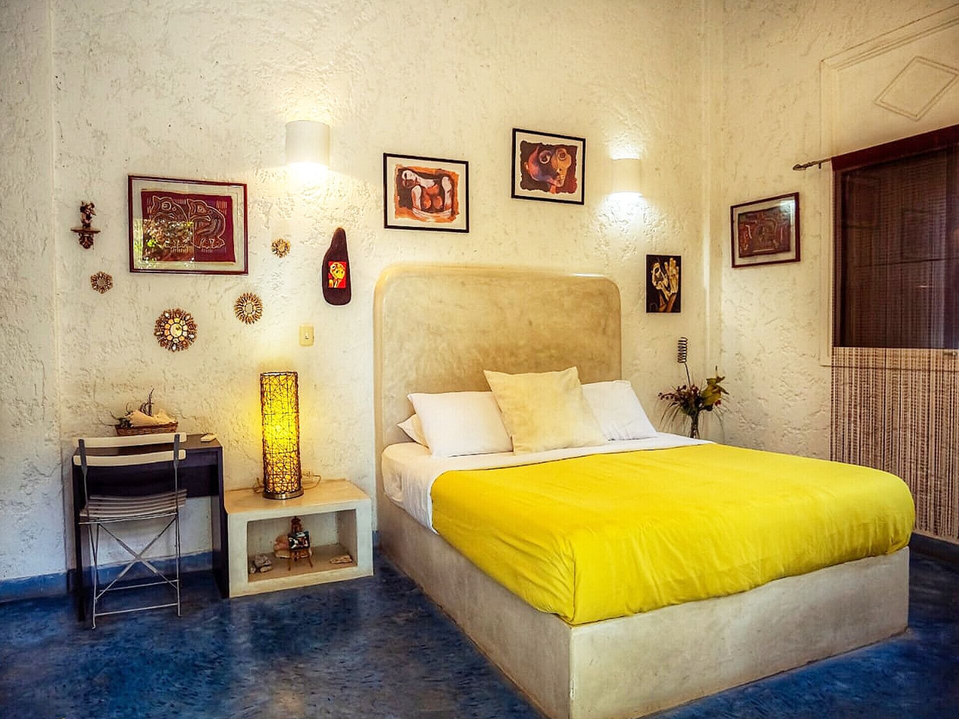 Un dormitorio con cama, mesita de noche, lámpara y adornos en la pared.