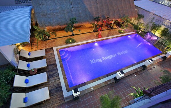 A swimming pool with lounge chairs and a sign that reads "Xing Angkor hotel." - Xing Angkor Hotel (Siem Reap)