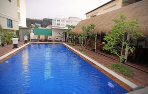A swimming pool with lounge chairs and a thatched-roof structure. - Xing Angkor Hotel (Siem Reap)
