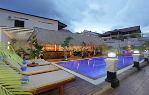 A pool area with lounge chairs and a thatched-roof structure. - Xing Angkor Hotel (Siem Reap)