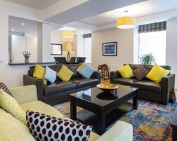 Una sala moderna con un conjunto de sofás, una mesa de centro y una zona de comedor con sillas.