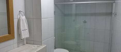 Une salle de bain avec une douche à parois de verre, des toilettes et un lavabo en marbre.