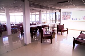 Relax in a quiet, well-designed library with high ceilings, large windows, and comfortable seating options.