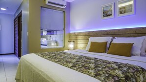 A bedroom with a large bed, a wooden headboard, and a window with blinds. - Pousada Kanaloa (Jijoca de Jericoacoara)