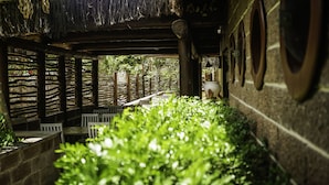 A covered outdoor seating area with wooden tables and chairs, surrounded by lush greenery. - Pousada Kanaloa (Jijoca de Jericoacoara)